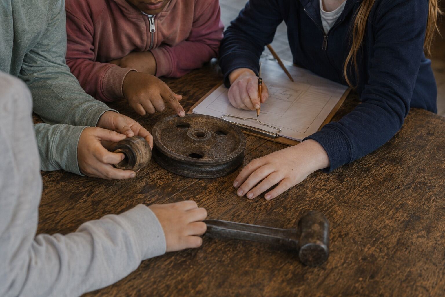 Children examining a mill pulley and recording it on an evidence sheet at Historic Rivermill