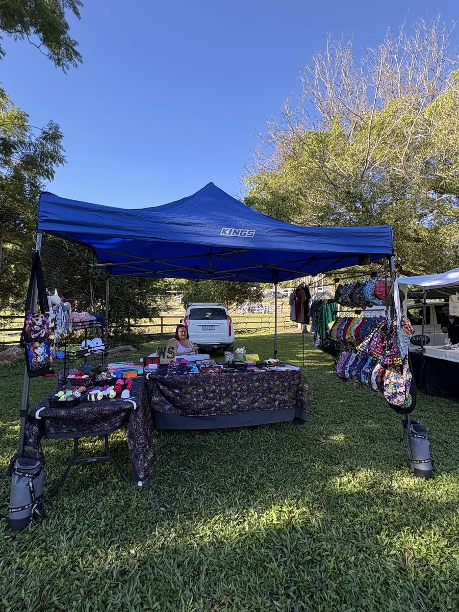 Goods laid out across tables under a marquee, with further stalls behind