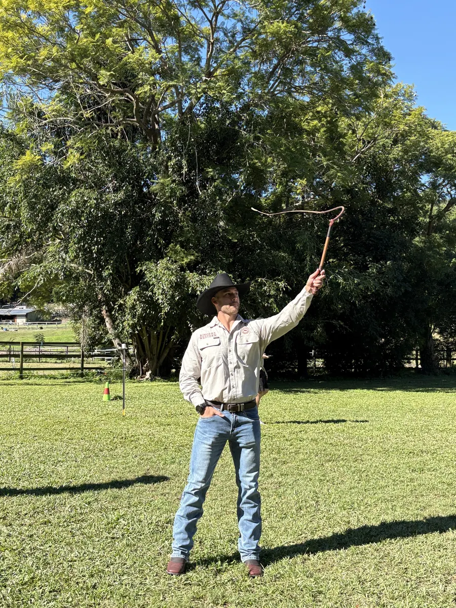 A Ringers Western performer cracking a whip on the lawn during the show