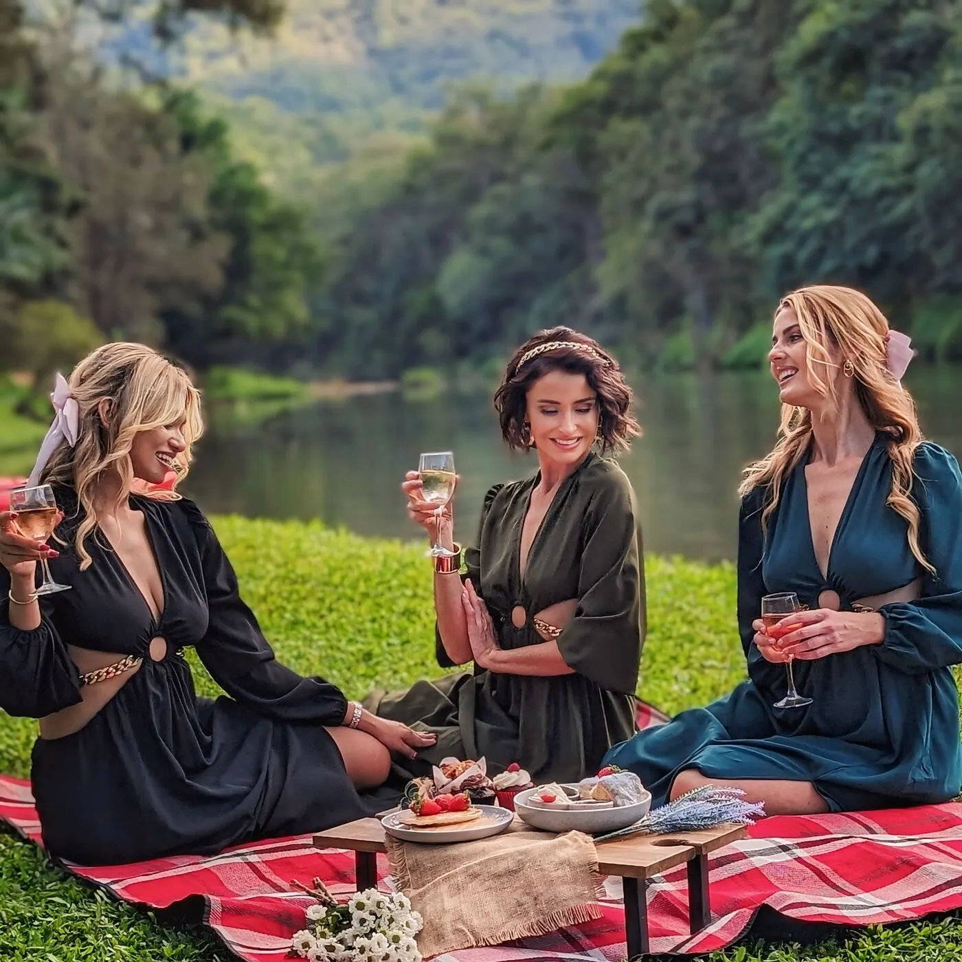 Friends sharing wine and a picnic by the Coomera River at Historic Rivermill