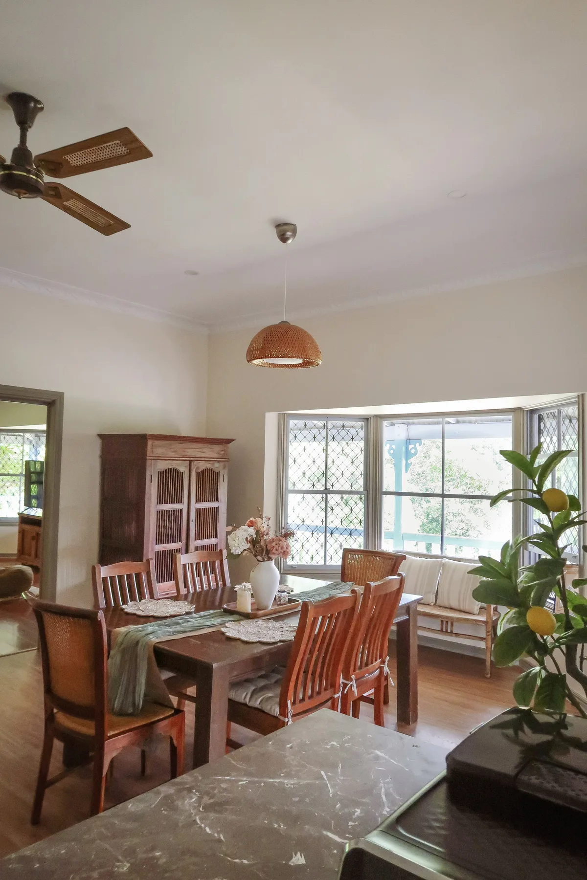 The dining room, a timber table for six by a bay window onto the garden