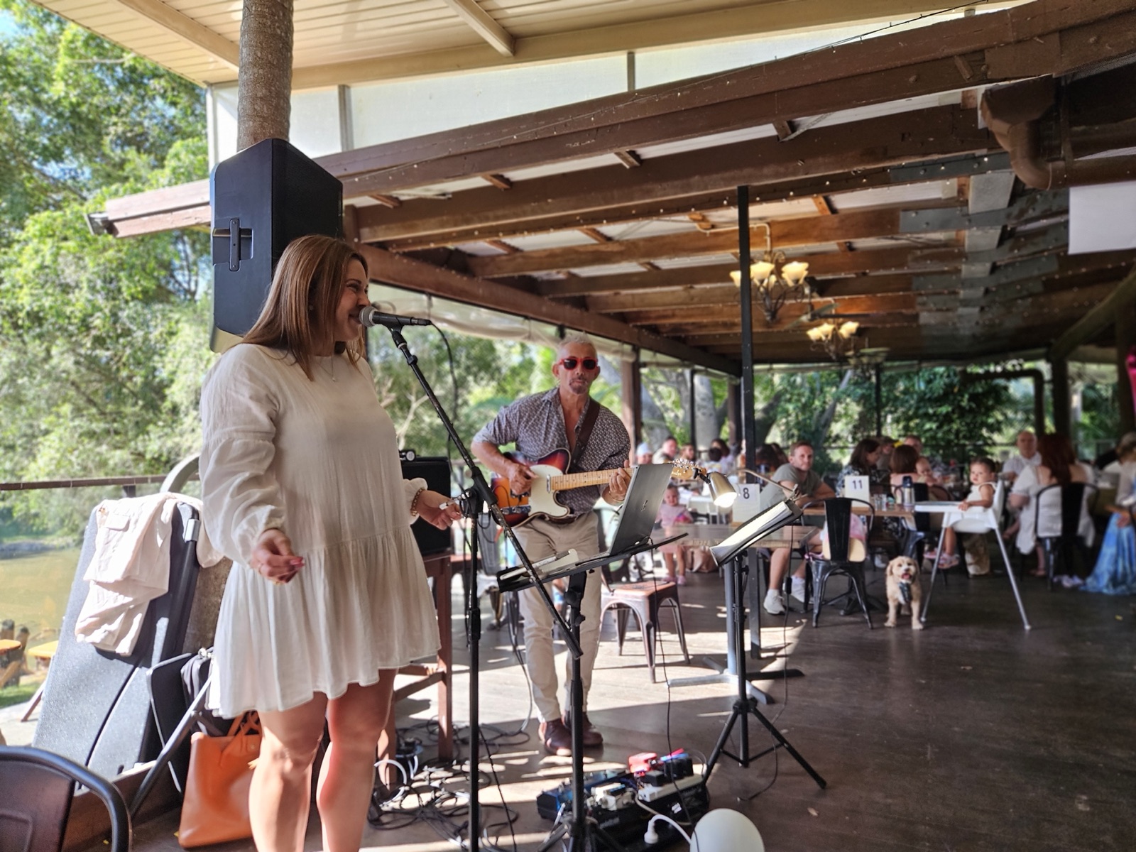A singer and guitarist performing live for diners on the riverside caf&eacute; deck at Historic Rivermill