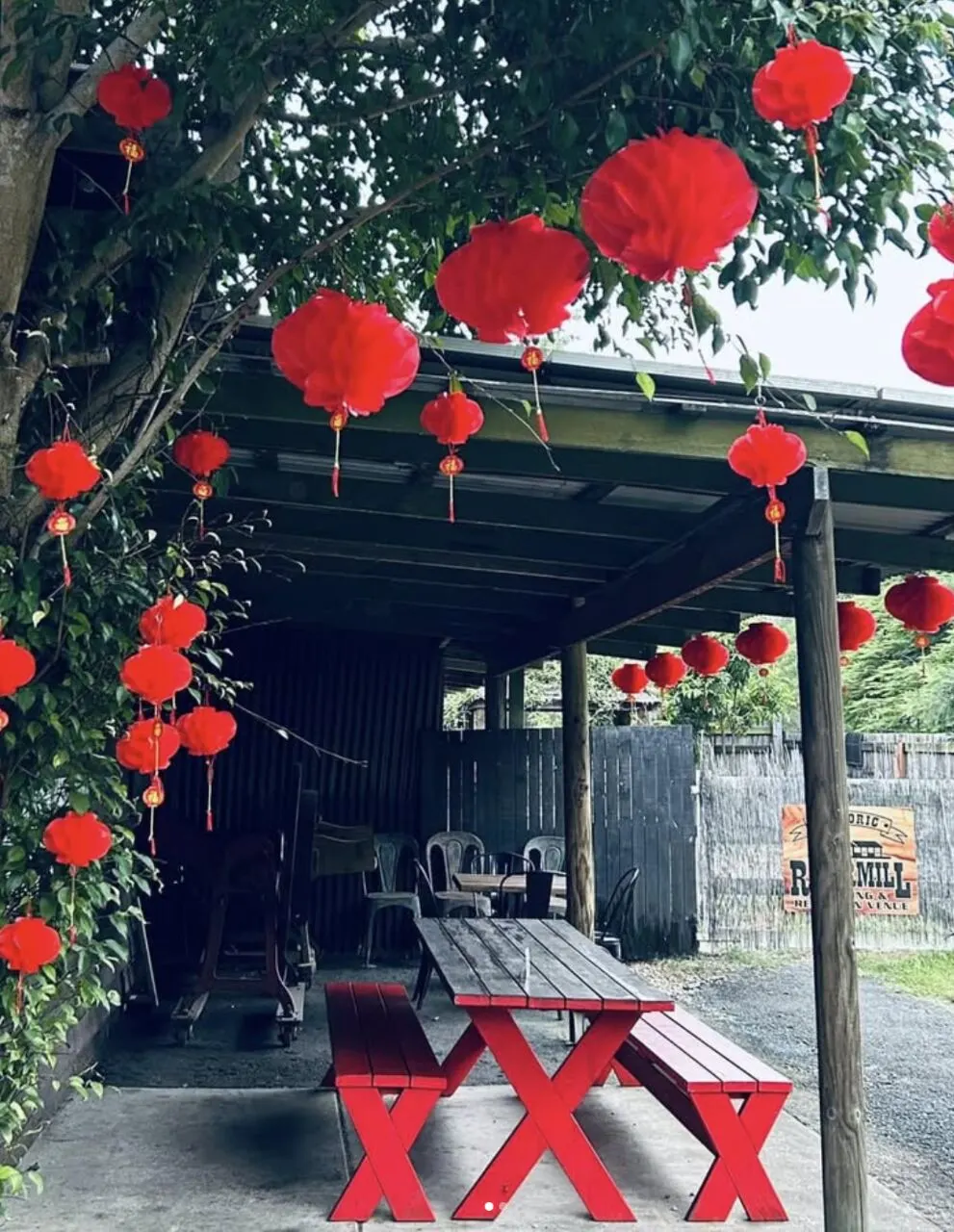 The Red Tables, an undercover outdoor area with red picnic tables and lantern decorations